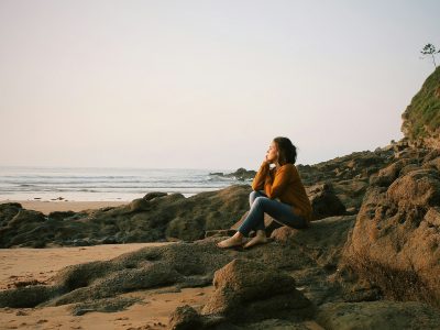 woman sitting near sea during daytime