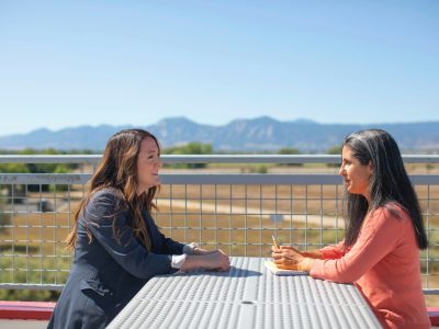 woman in black long sleeve shirt sitting on white wooden bench during daytime