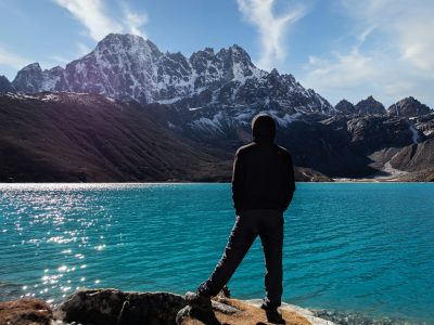a person standing on a rock near a body of water